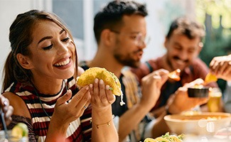 Woman smiling while eating lunch with friends at restaurant