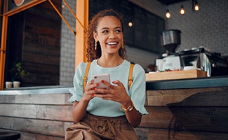 Smiling woman sitting on barstool at restaurant