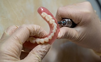 Lab technician filing dentures