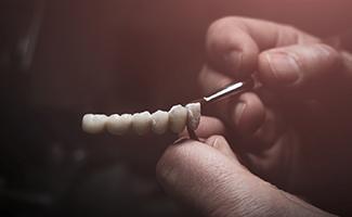 Lab technician painting replacement teeth