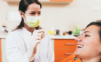 A dentist holding a patient’s extracted tooth