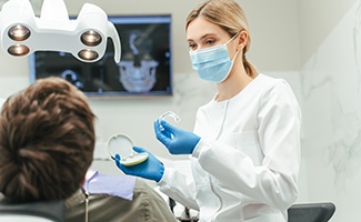 Dentist showing patient clear aligner in treatment room