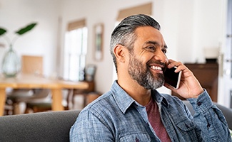 Man smiling while talking on phone
