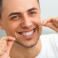 man flossing his teeth to prevent dental emergencies in Reno