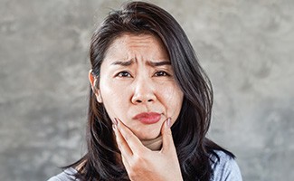 Patient in Reno holding their cheek needing root canals